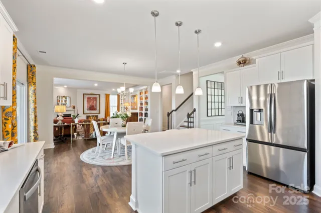 a view of a dining room and livingroom with furniture wooden floor a chandelier
