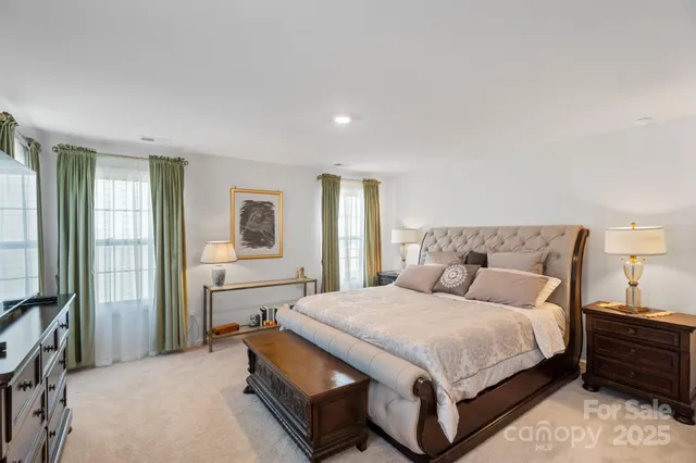 a spacious bedroom with a bed and a lamp