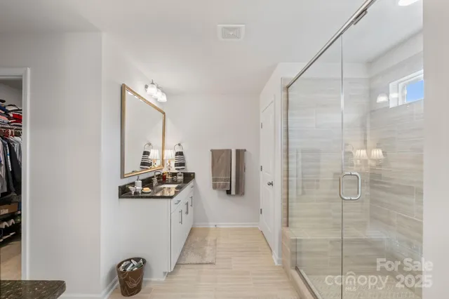 a bathroom with a granite countertop double vanity and a mirror