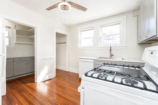 a white stove top oven sitting inside of a kitchen