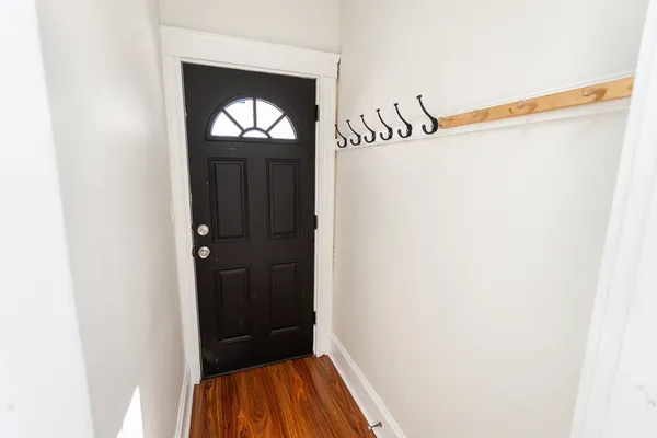 a view of a hallway with wooden floor and staircase