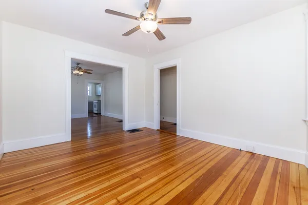 a view of an empty room with wooden floor