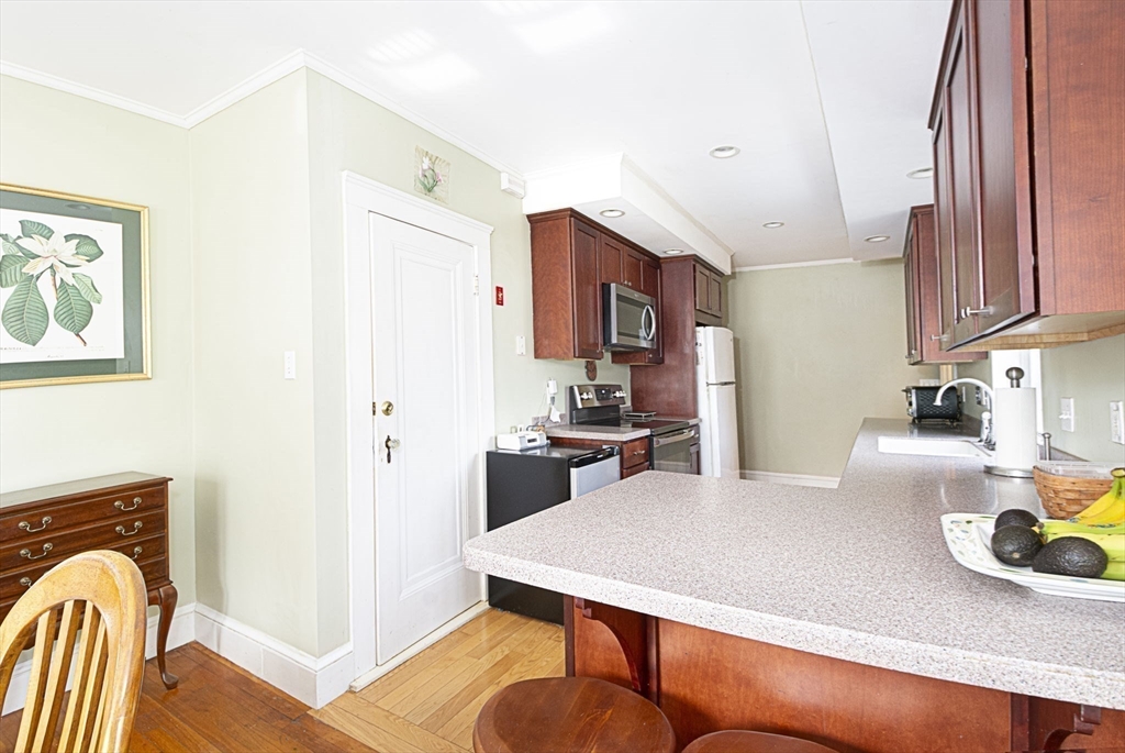 15 Monroe Street Shrewsbury, MA 01545 - Photo 12 of 30 a kitchen with stainless steel appliances wooden floor dining table and chairs