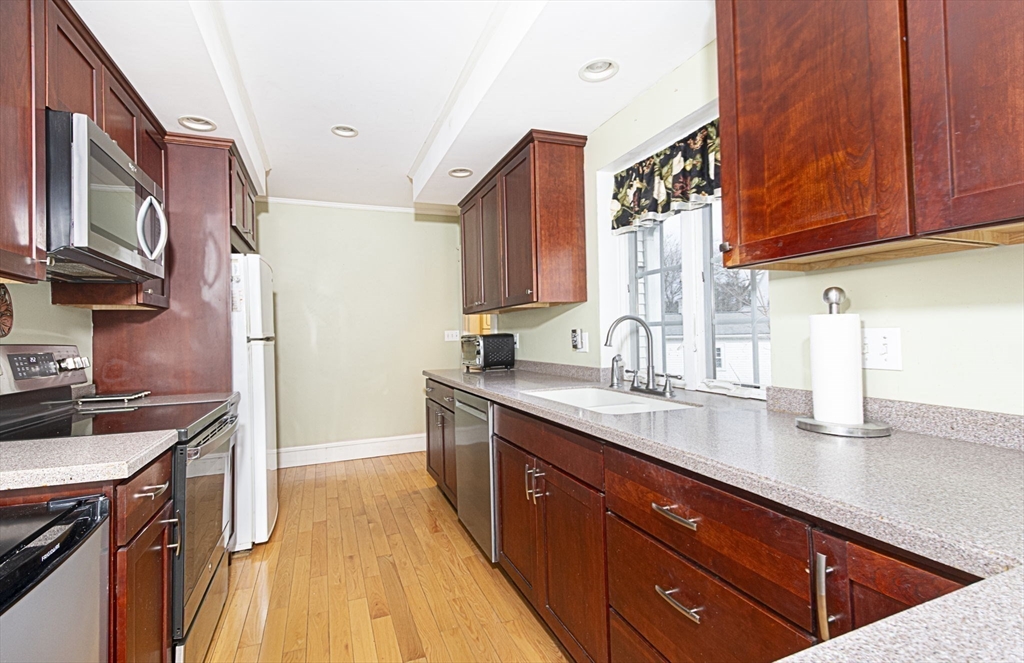 15 Monroe Street Shrewsbury, MA 01545 - Photo 8 of 30 a kitchen with stainless steel appliances granite countertop a sink stove and cabinets