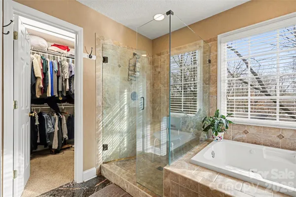 a bathroom with a granite countertop tub shower and sink