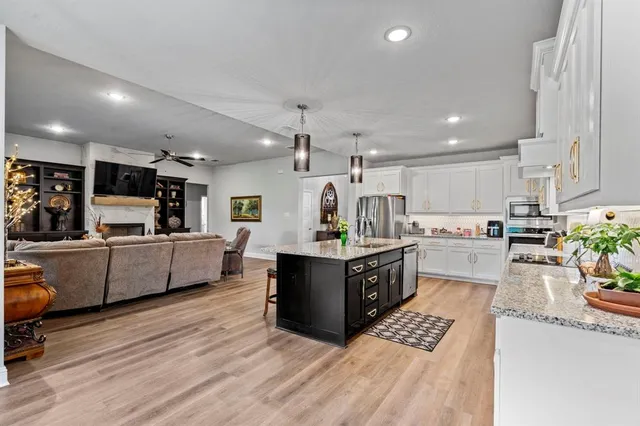 a large kitchen with stainless steel appliances sink microwave and cabinets
