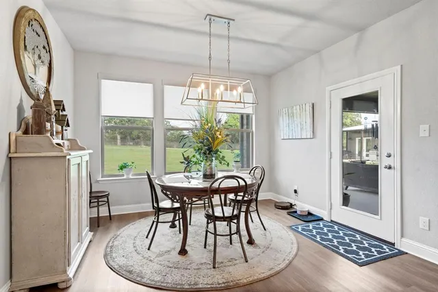a dining room with furniture a chandelier and wooden floor