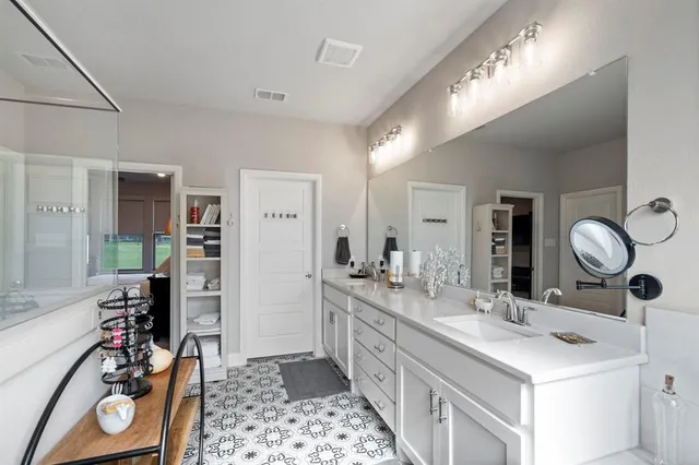 a bathroom with double vanity and a mirror