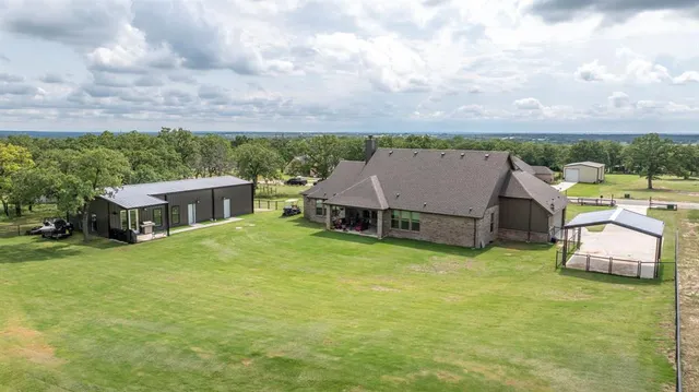 an aerial view of a house with swimming pool and furniture