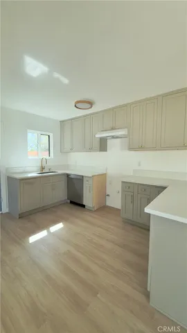 a view of a kitchen with wooden floor and electronic appliances