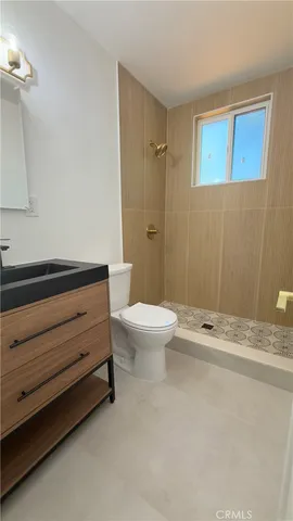 a bathroom with a granite countertop sink a toilet and a mirror