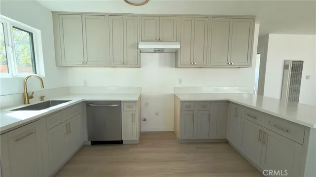 a kitchen with white cabinets and sink