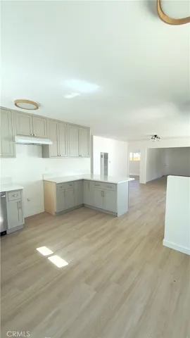a view of empty room with wooden floor and window
