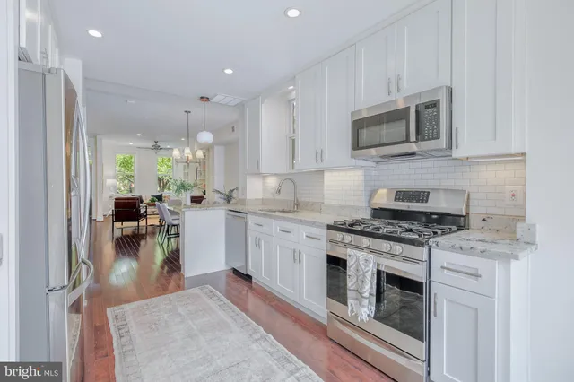 a kitchen with stainless steel appliances a stove refrigerator sink and microwave