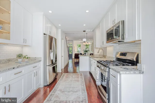 a kitchen with stainless steel appliances a stove sink and cabinets