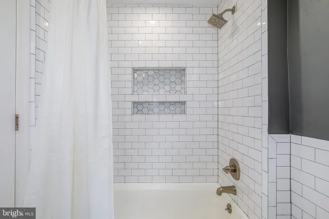 a view of a hallway with a livingroom and a bathroom