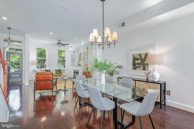 a dining room with furniture potted plants and wooden floor