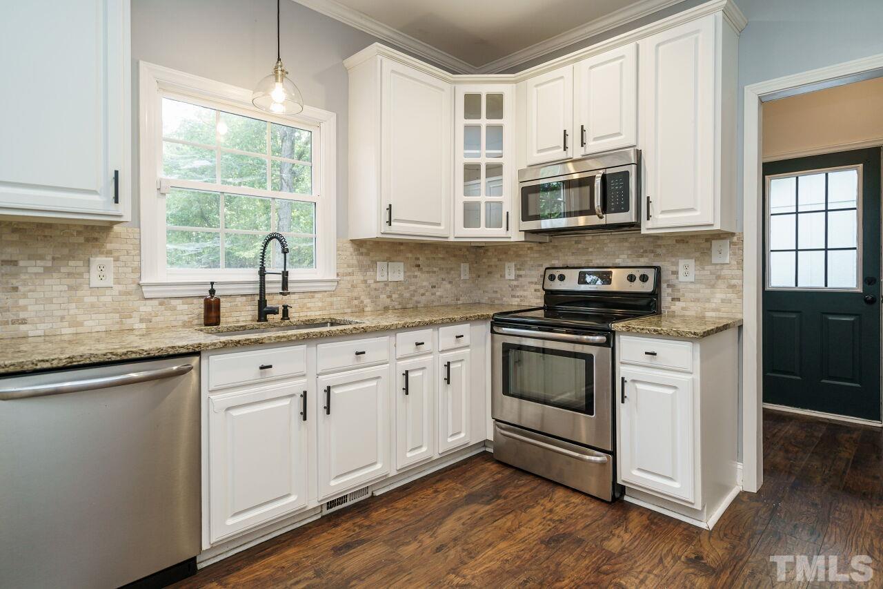 4202 Holt School Road Durham, NC 27704 - Photo 11 of 27 a kitchen with stainless steel appliances granite countertop a stove a sink and a microwave