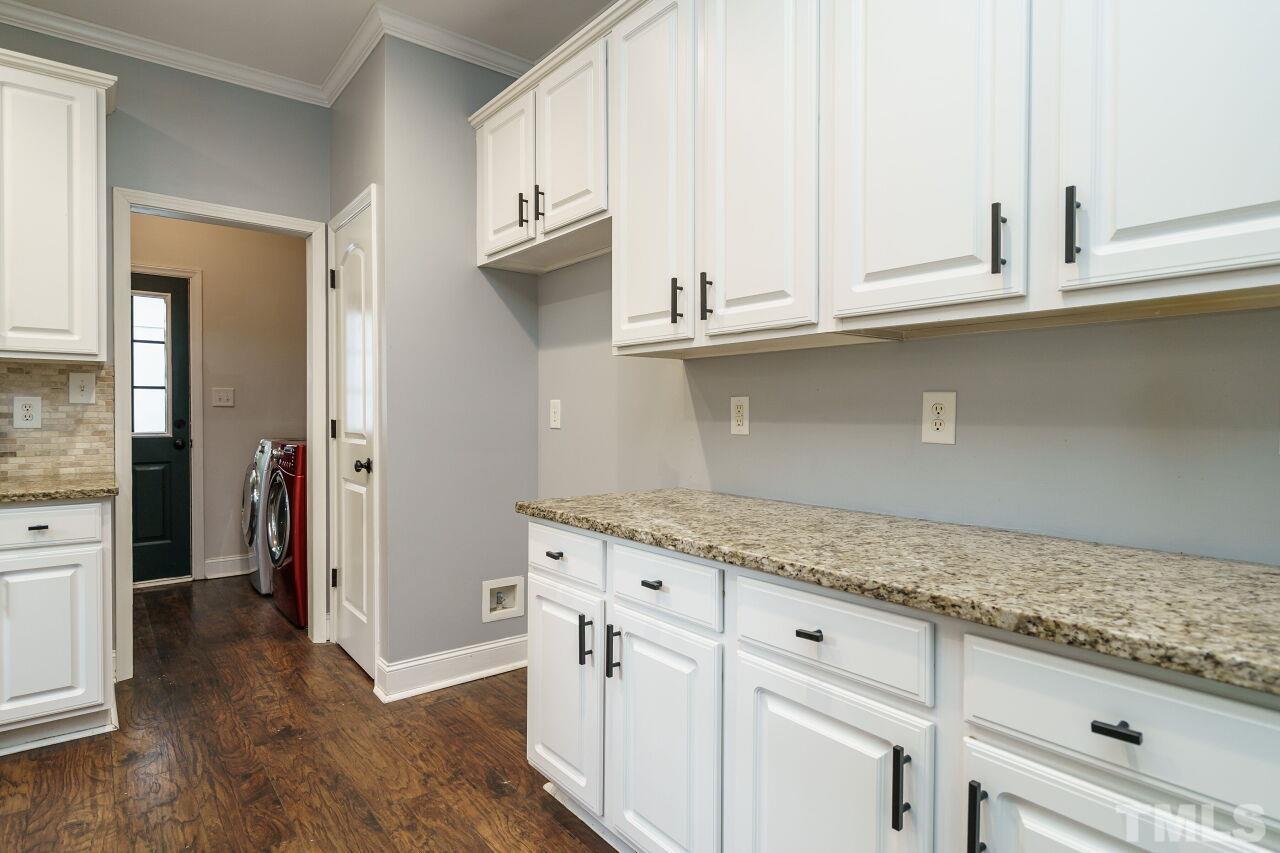 4202 Holt School Road Durham, NC 27704 - Photo 12 of 27 a kitchen with granite countertop white cabinets and a sink