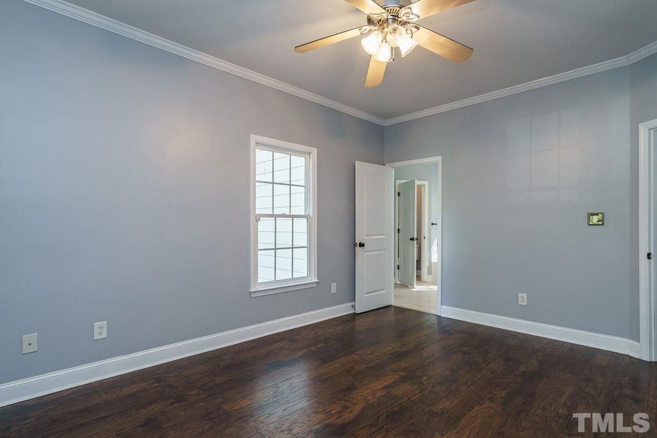 4202 Holt School Road Durham, NC 27704 - Photo 17 of 27 an empty room with wooden floor chandelier fan and windows