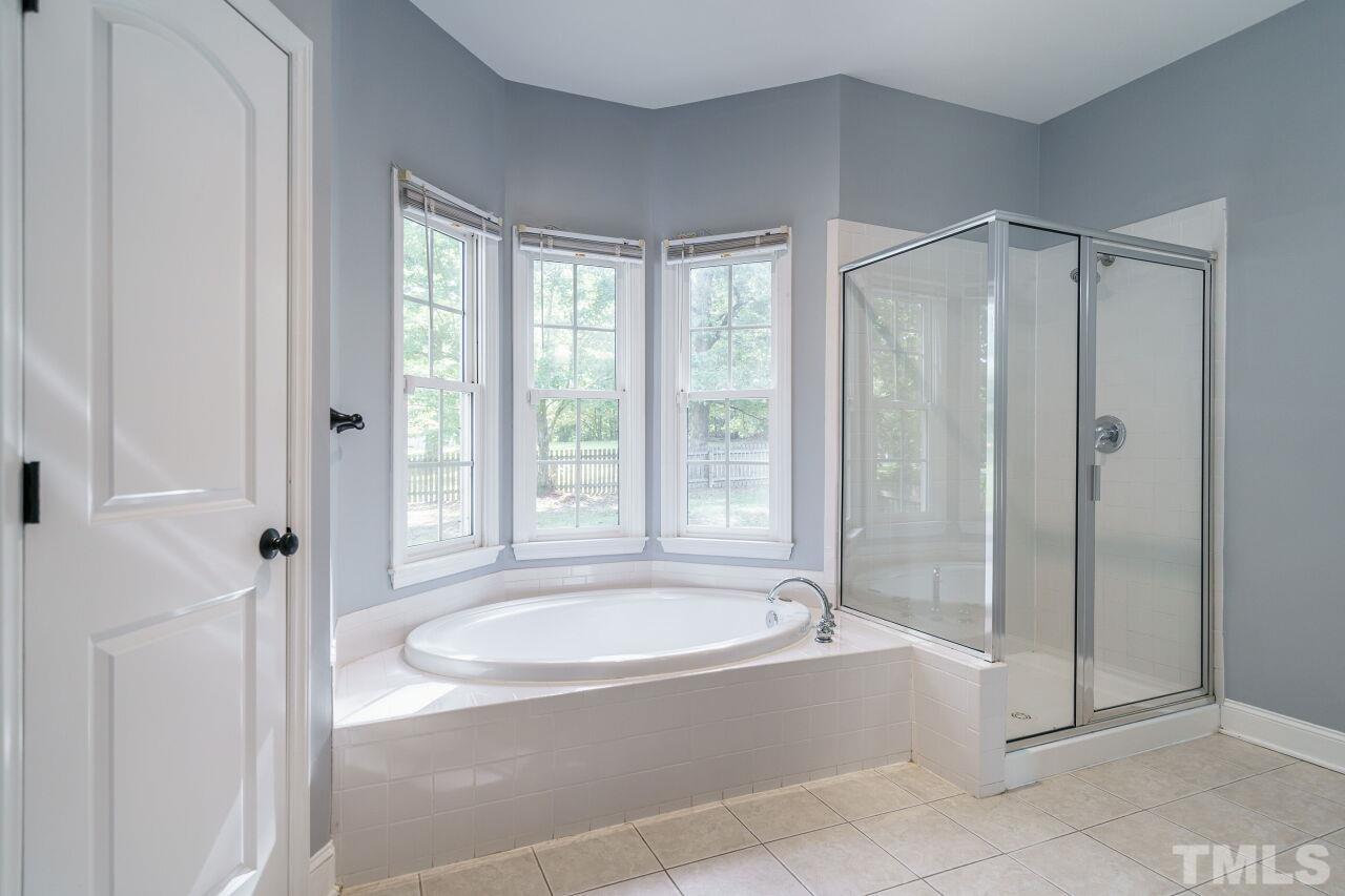 4202 Holt School Road Durham, NC 27704 - Photo 19 of 27 a spacious bathroom with a tub shower and window