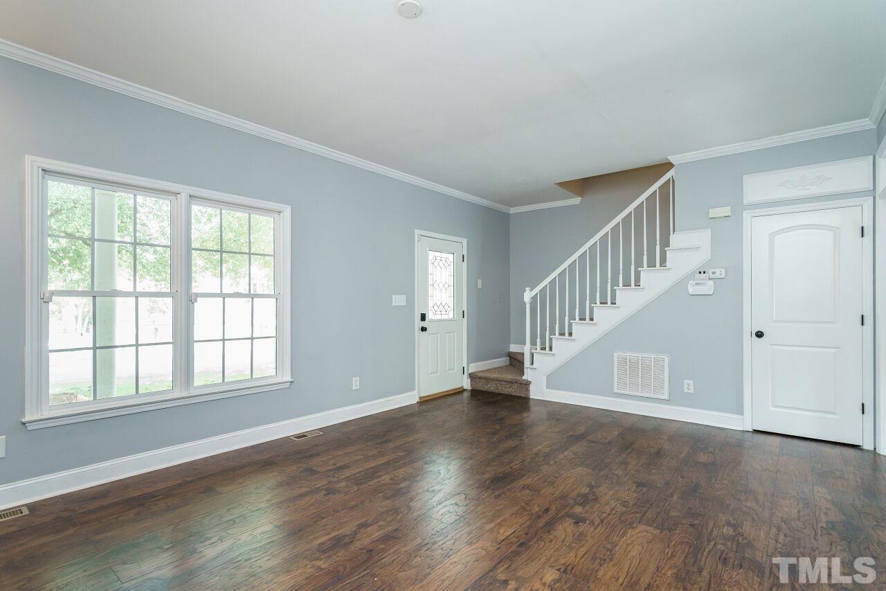 4202 Holt School Road Durham, NC 27704 - Photo 7 of 27 a view of an empty room with wooden floor and a window