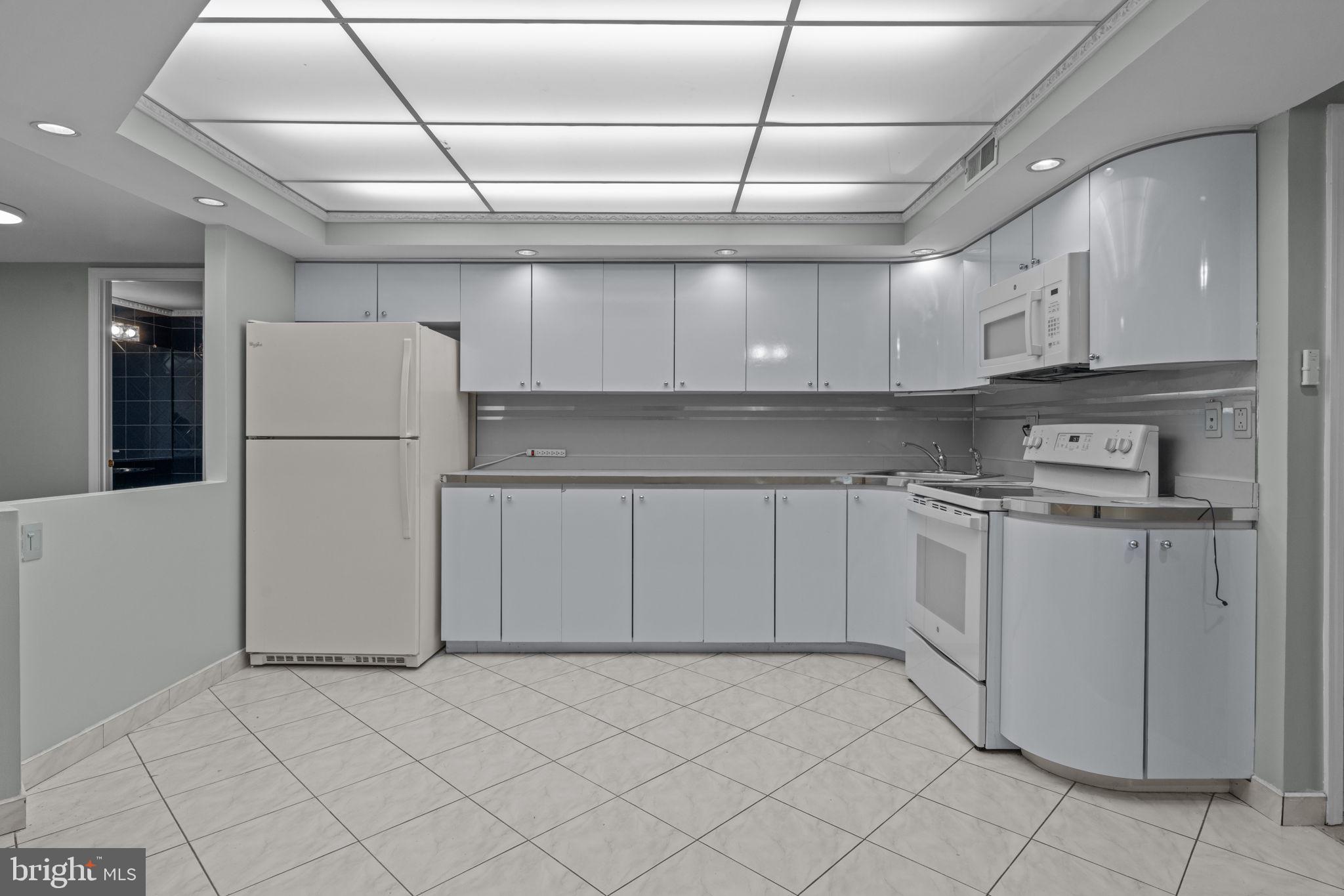 2131 Welsh Road, Unit 208 Philadelphia, PA 19115 - Photo 12 of 21 a kitchen with white cabinets and refrigerator