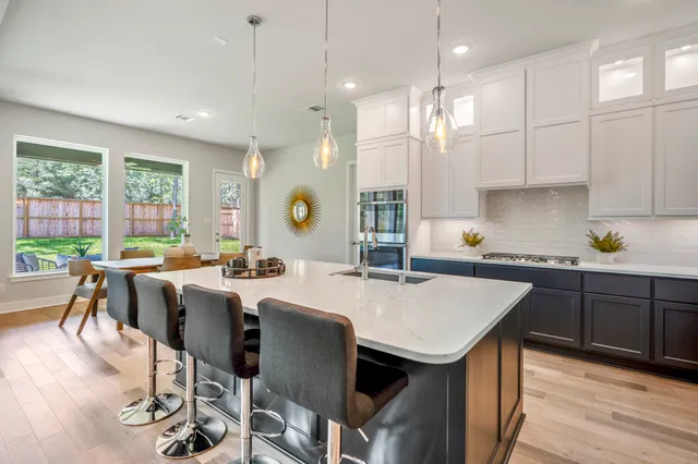 a kitchen with a table chairs stove and wooden floor