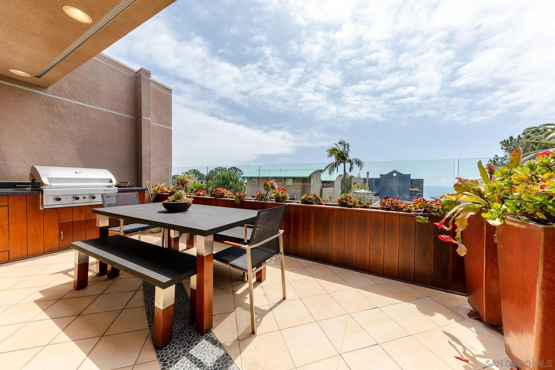 13748 Pine Needles Drive Del Mar, CA 92014 - Photo 40 of 49 a terrace with a table and chairs and potted plants