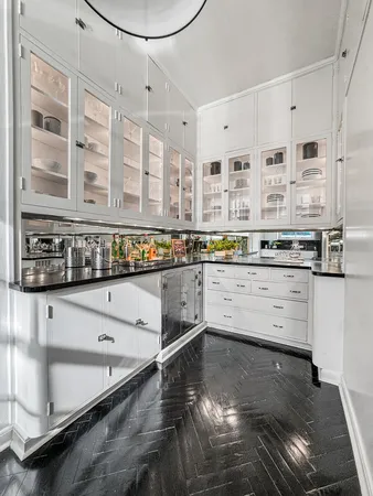 a kitchen with cabinets and wooden floor