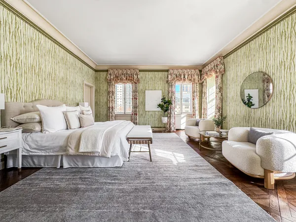 a spacious bedroom with a bed and wooden floor