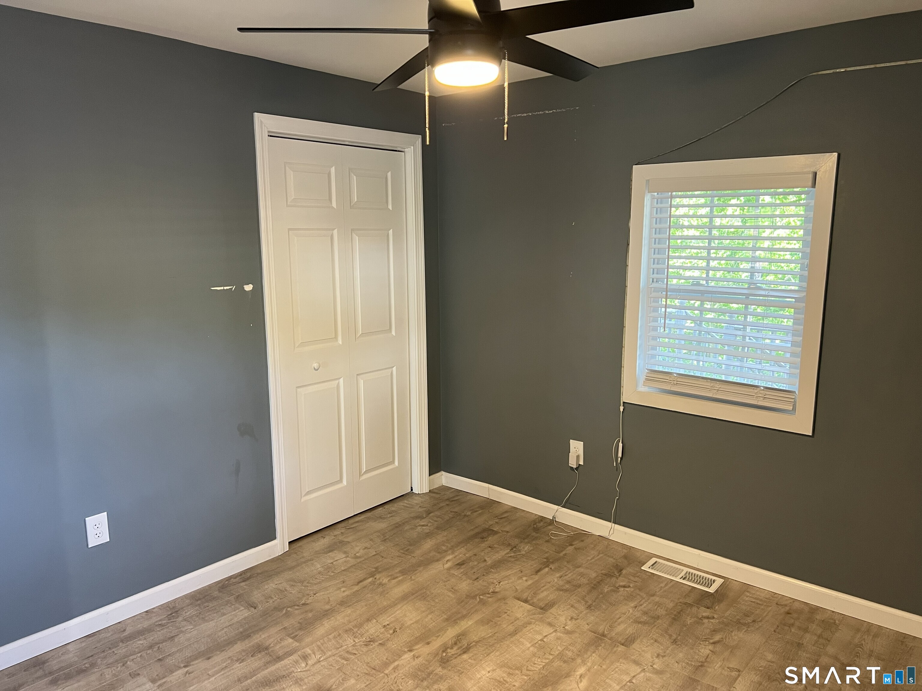 82 Bingham Street Bristol, CT 06010 - Photo 30 of 40 a view of an empty room with window and wooden floor
