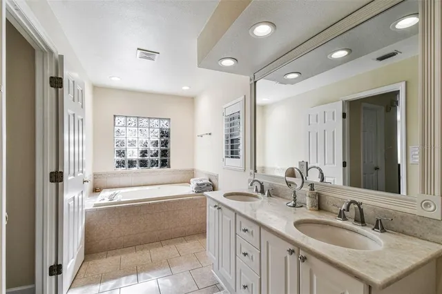 a bathroom with a tub sink and mirror
