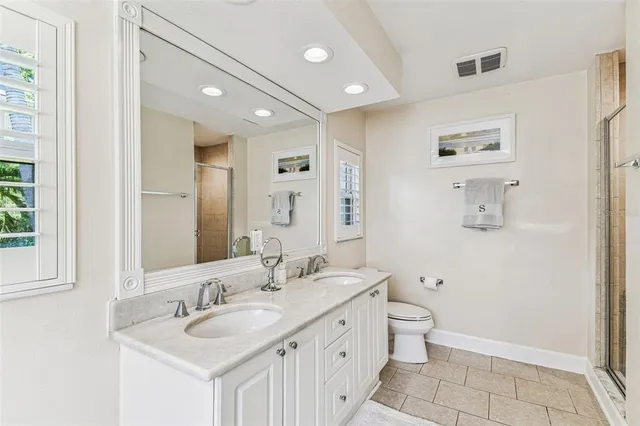 a bathroom with a double vanity sink mirror and toilet