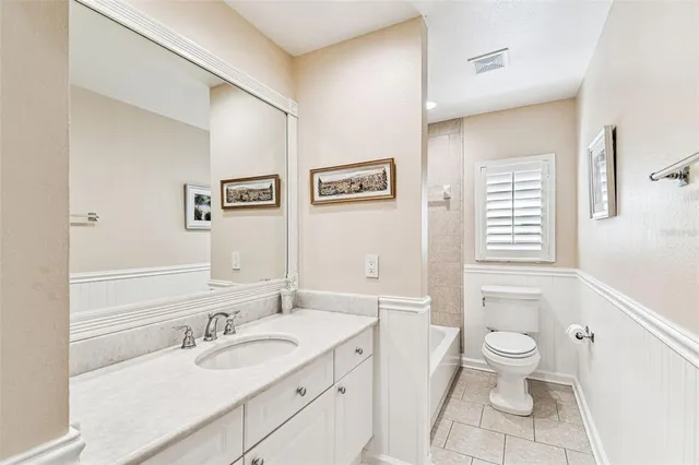 a bathroom with a granite countertop sink a toilet a and a mirror