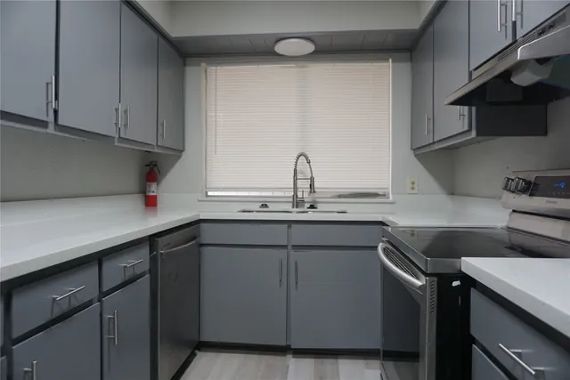 a kitchen with a sink cabinets and appliances