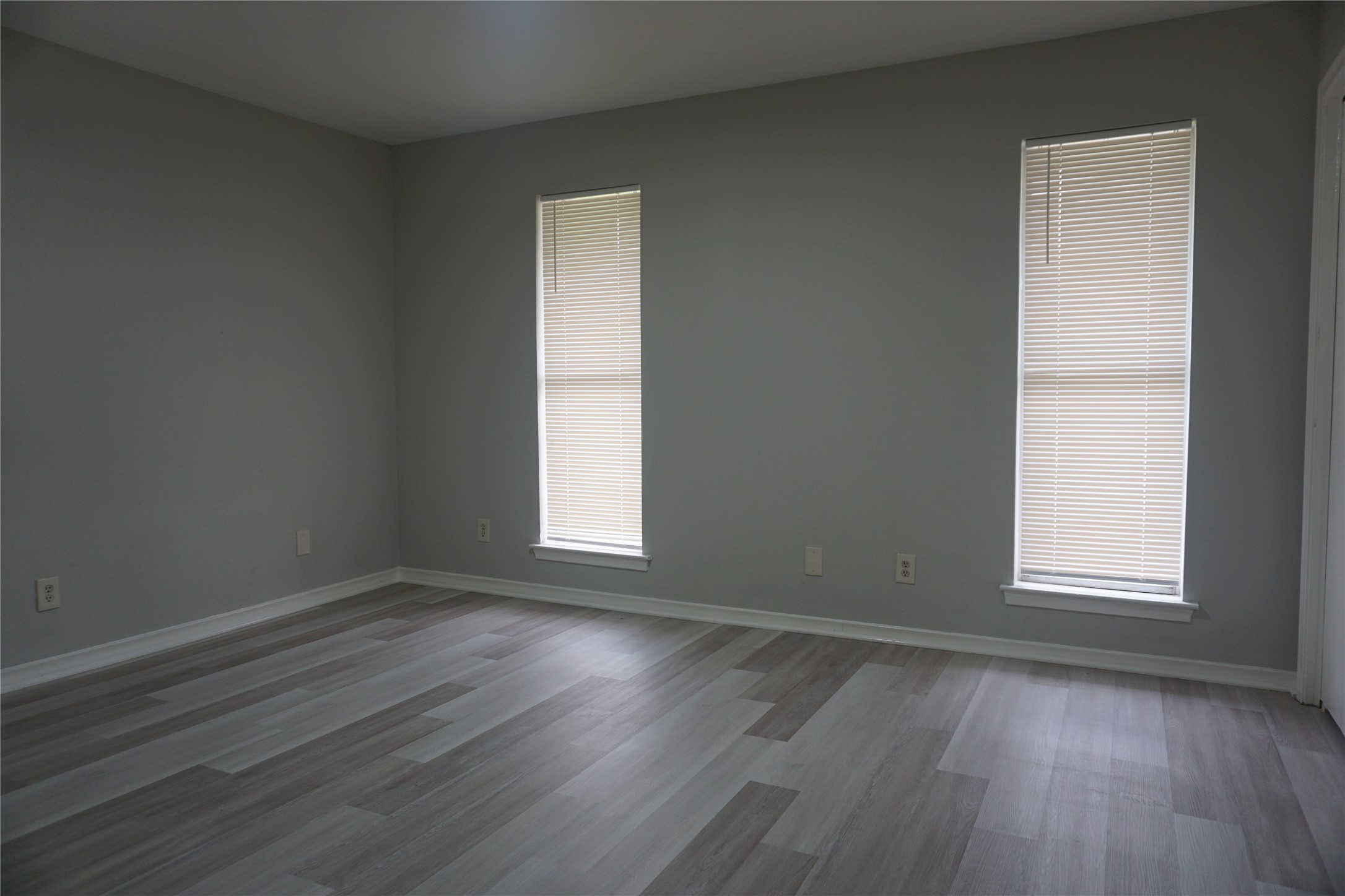 1913 Normal Park Drive, Unit B Huntsville, TX 77340 - Photo 14 of 29 an empty room with wooden floor and windows