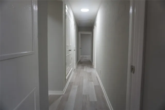 a view of a hallway with wooden floor