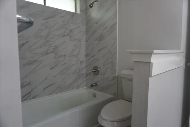 a bathroom with a toilet and bathtub