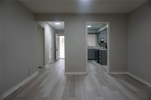 a view of a big room with wooden floor and a kitchen