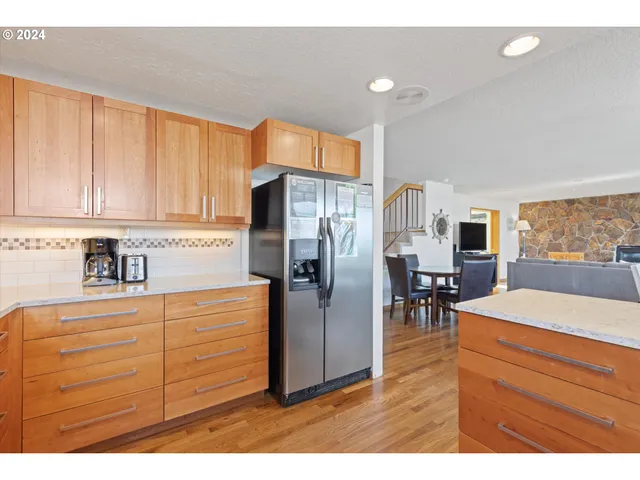 a kitchen with kitchen island a counter top space cabinets and stainless steel appliances