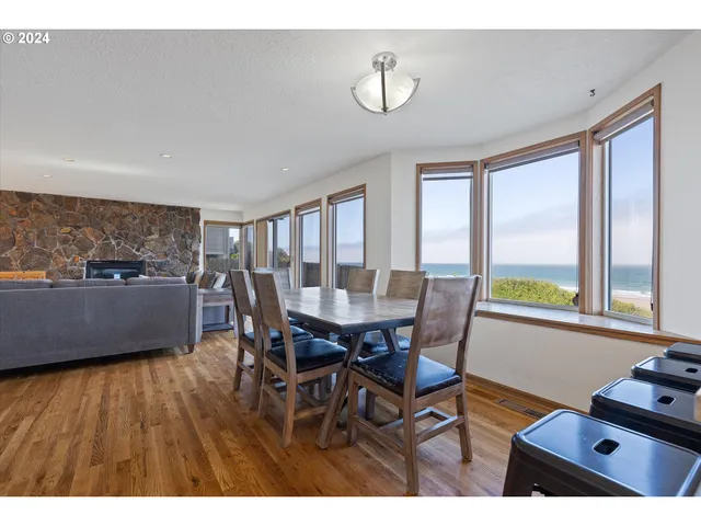a view of a dining room with furniture a rug and wooden floor