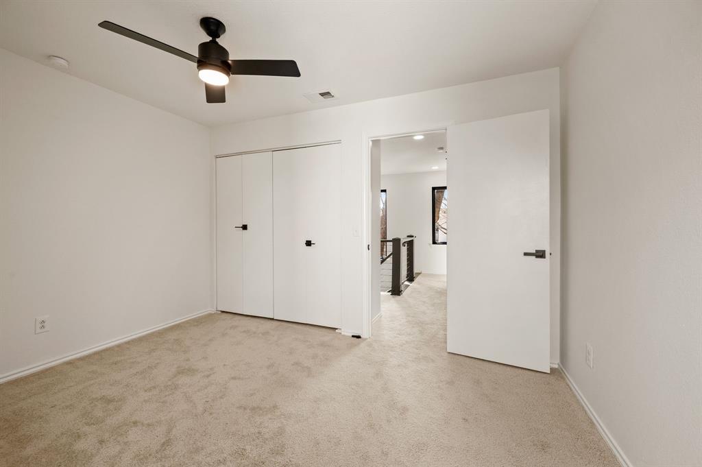 5009 Milam Street Dallas, TX 75206 - Photo 26 of 35 Unfurnished bedroom featuring light carpet, a ceiling fan, and a closet