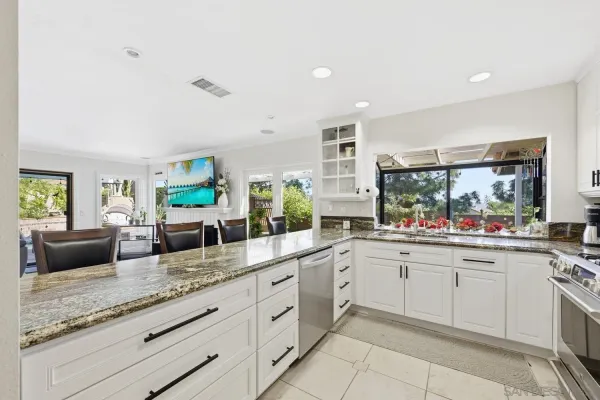 a kitchen with granite countertop a sink counter top space appliances and cabinets