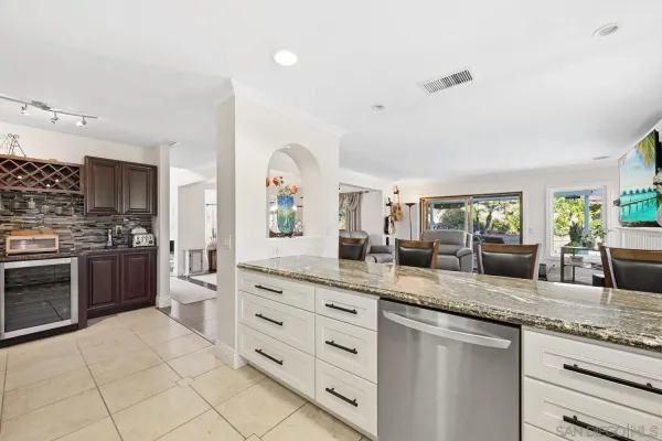 a kitchen with stainless steel appliances granite countertop a stove top oven a sink dishwasher a refrigerator and cabinets with wooden floor