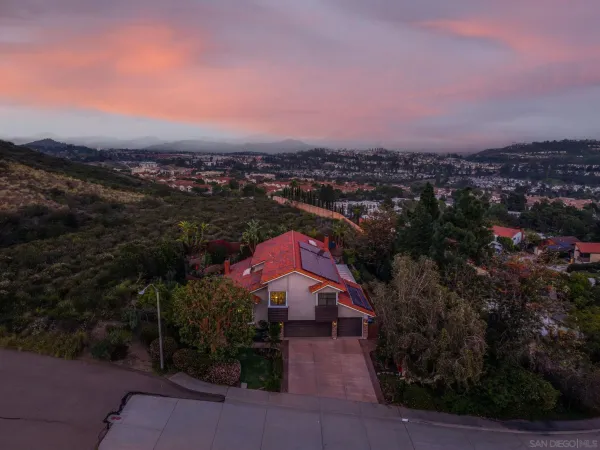 an aerial view of residential houses with outdoor space and trees