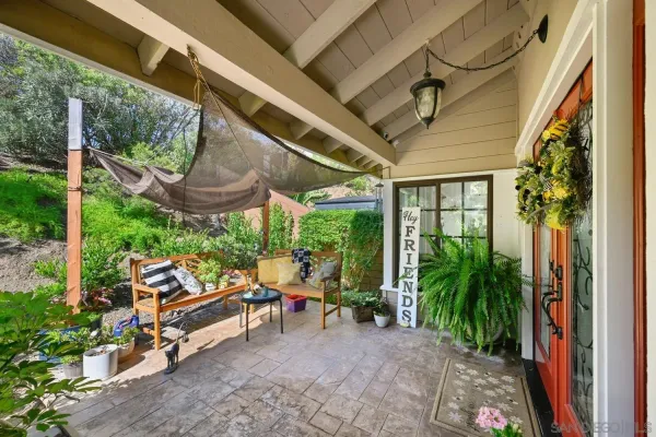 a view of a patio with table and chairs potted plants and floor to ceiling window and potted plants