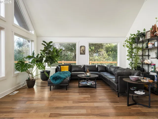 a living room with furniture potted plant floor to ceiling windows and a fireplace
