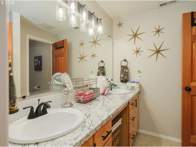 a bathroom with a granite countertop sink and a mirror