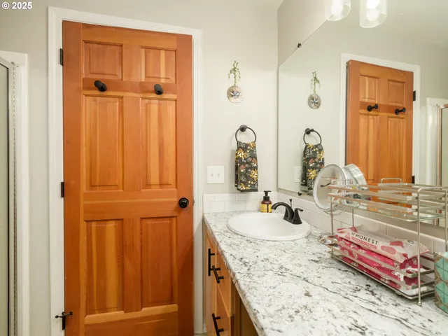 a bathroom with a granite countertop sink and a mirror